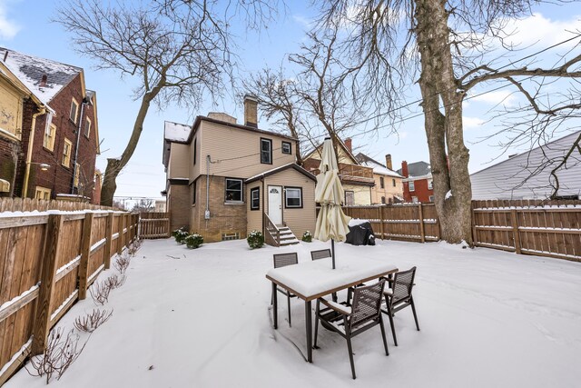 view of snow covered back of property