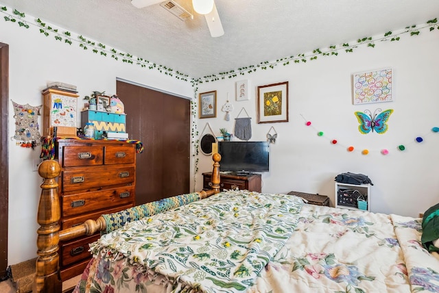 bedroom with ceiling fan and a textured ceiling