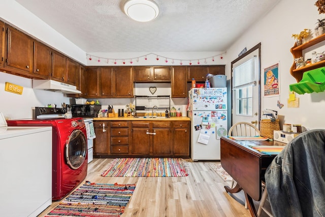 kitchen with independent washer and dryer, white refrigerator, a textured ceiling, and sink