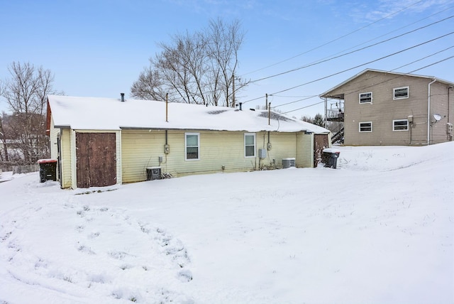 snow covered house with central AC unit