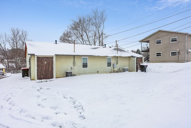 snow covered back of property with central air condition unit