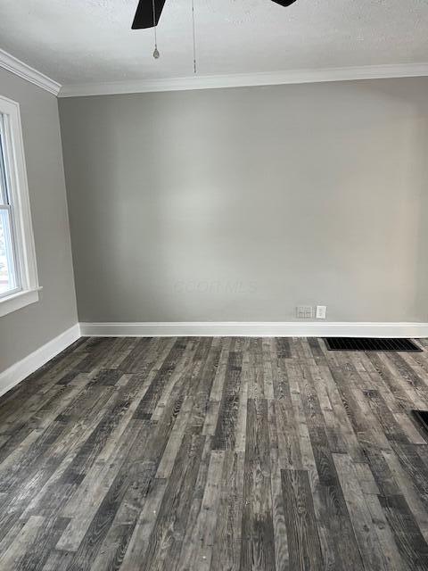 unfurnished room featuring crown molding, ceiling fan, dark wood-type flooring, and a textured ceiling