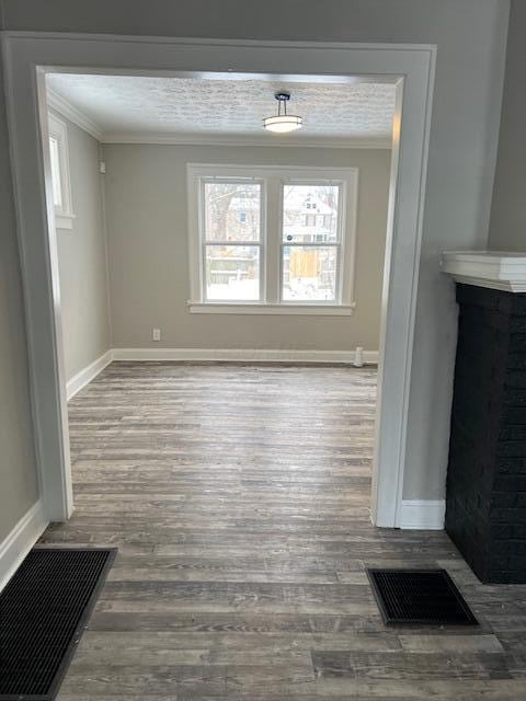 unfurnished dining area with crown molding and wood-type flooring