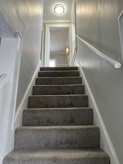 staircase with a textured ceiling