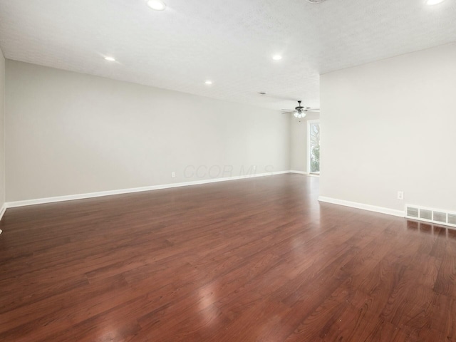 empty room with a textured ceiling and dark hardwood / wood-style floors