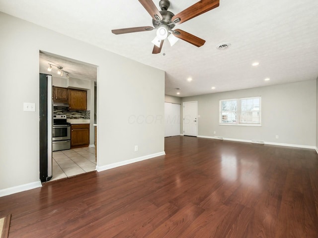 spare room featuring a textured ceiling, ceiling fan, and light hardwood / wood-style flooring