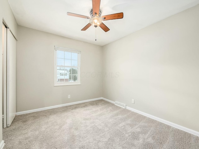 unfurnished bedroom featuring carpet floors, ceiling fan, and a closet