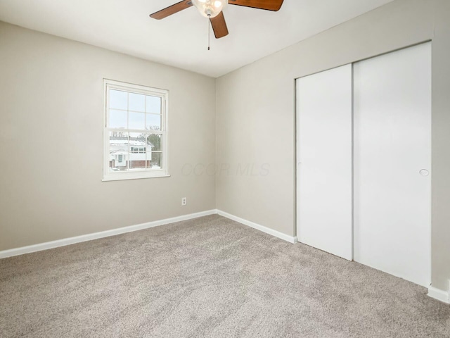 unfurnished bedroom featuring ceiling fan, a closet, and carpet