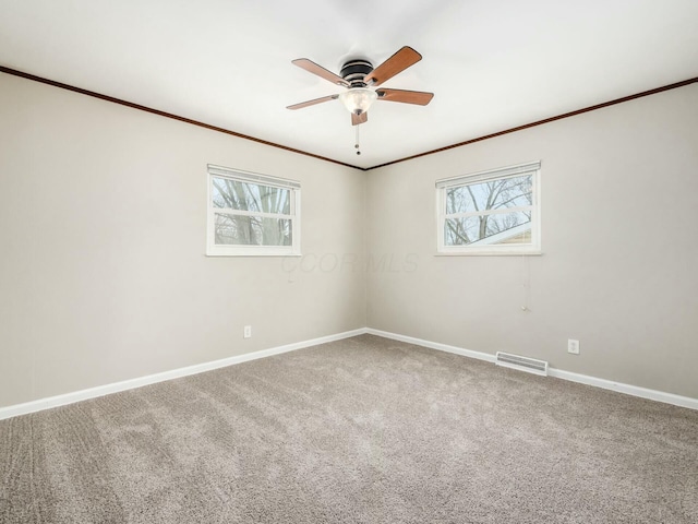 spare room with ceiling fan, plenty of natural light, crown molding, and carpet flooring