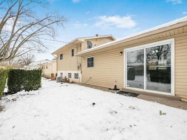 view of snow covered back of property