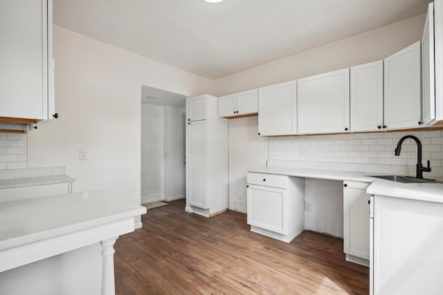 kitchen featuring backsplash, dark hardwood / wood-style flooring, sink, and white cabinets