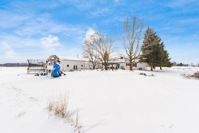 yard layered in snow featuring a playground