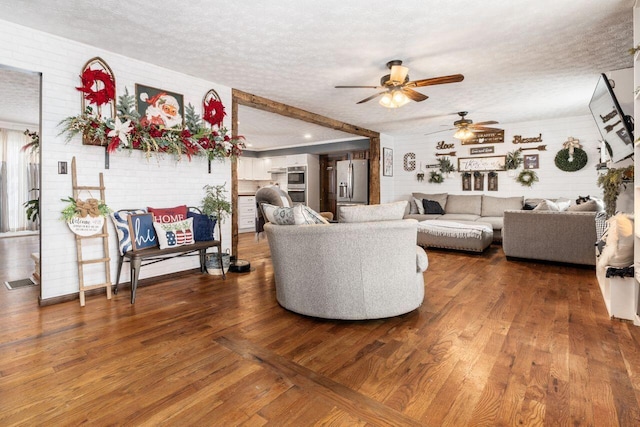 living room with ceiling fan, wood-type flooring, and a textured ceiling