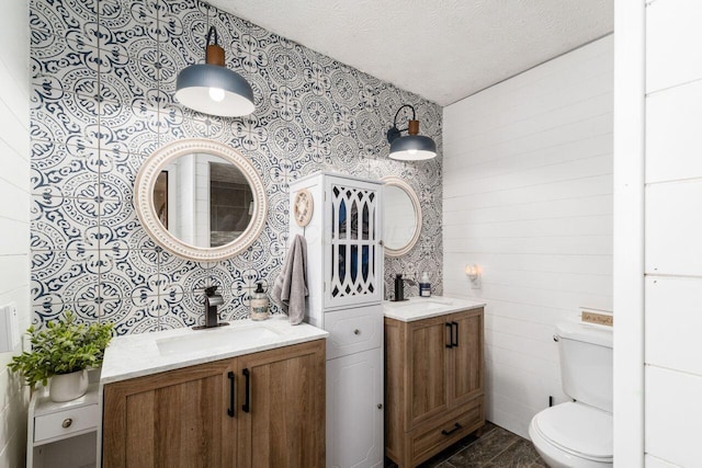 bathroom featuring vanity, toilet, and a textured ceiling