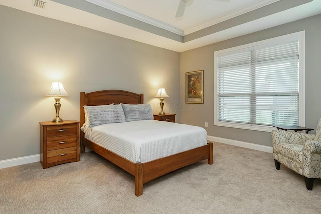 carpeted bedroom with a raised ceiling, ceiling fan, and crown molding