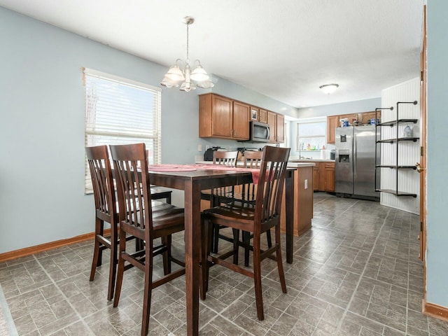 dining area with sink and a notable chandelier