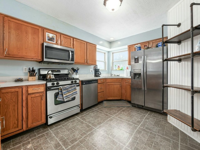 kitchen with appliances with stainless steel finishes and a textured ceiling