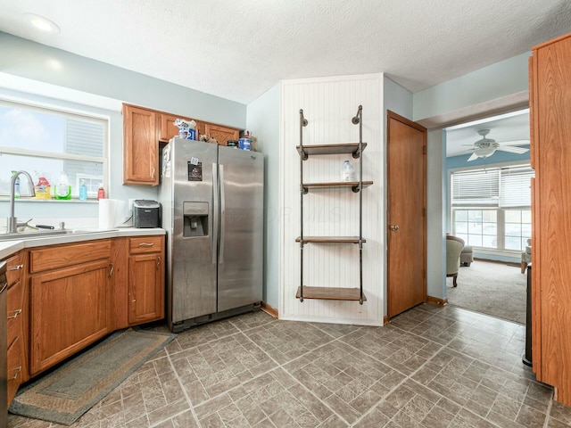 kitchen with ceiling fan, sink, stainless steel appliances, and a textured ceiling