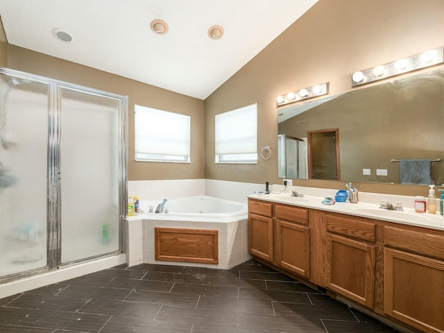 bathroom with vanity, lofted ceiling, and independent shower and bath