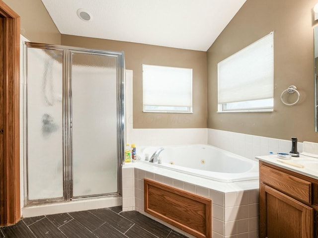 bathroom featuring shower with separate bathtub, vanity, and lofted ceiling