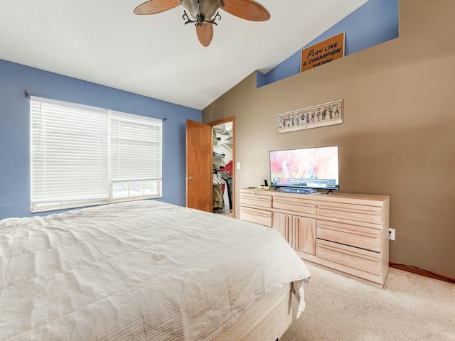 bedroom with light carpet, vaulted ceiling, ceiling fan, a spacious closet, and a closet