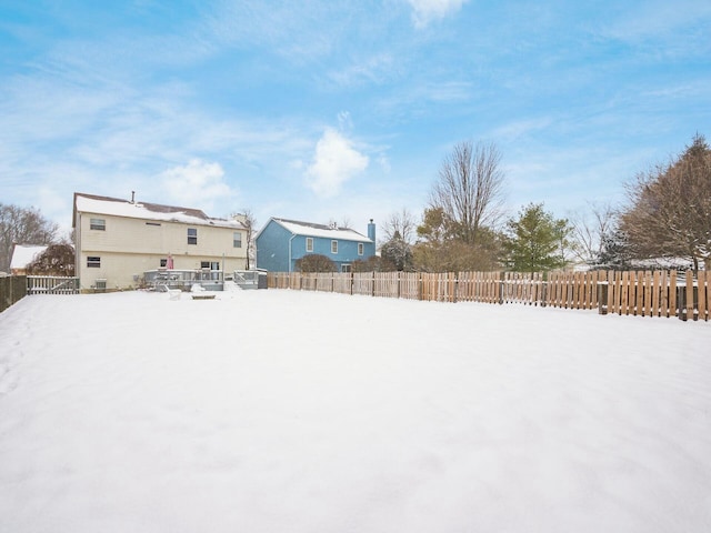 yard layered in snow featuring a deck