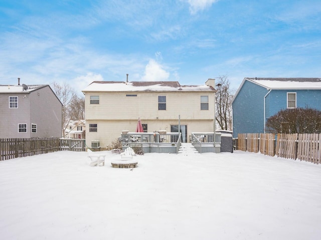 snow covered property with central AC unit and a wooden deck