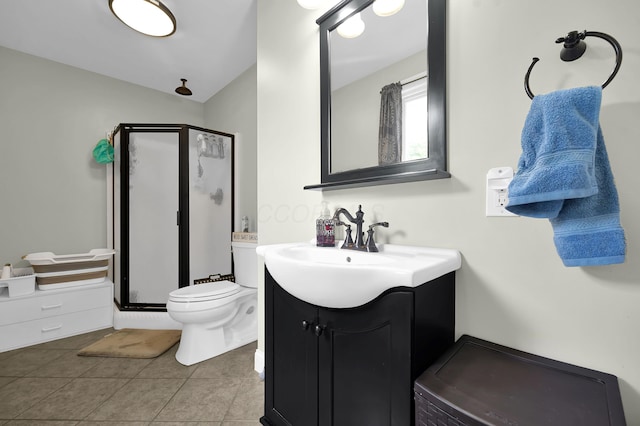 bathroom with tile patterned flooring, vanity, toilet, and walk in shower