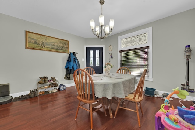 dining space with dark hardwood / wood-style flooring and an inviting chandelier