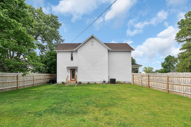 rear view of house with a lawn and central air condition unit