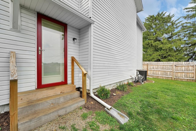 doorway to property featuring a yard and central AC