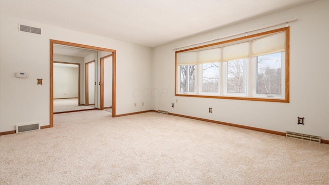 unfurnished room featuring light carpet