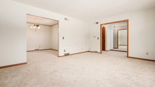 spare room with carpet flooring and a chandelier