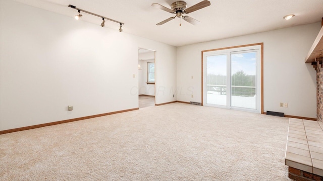 carpeted empty room with ceiling fan and rail lighting