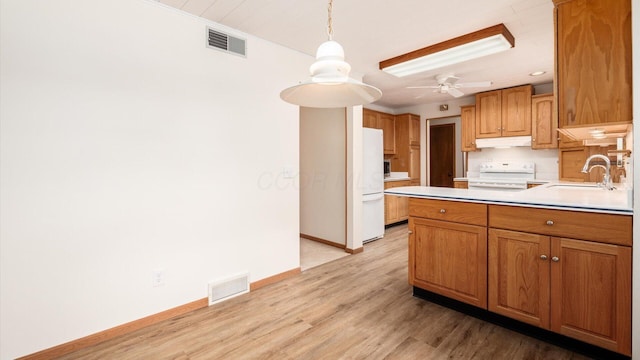 kitchen featuring ceiling fan, sink, light hardwood / wood-style floors, pendant lighting, and range