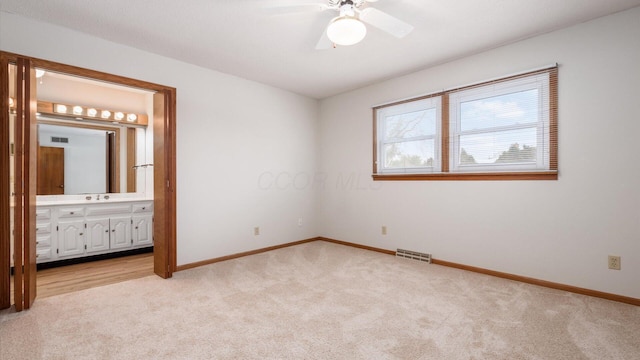 unfurnished bedroom featuring ensuite bath, ceiling fan, and light carpet