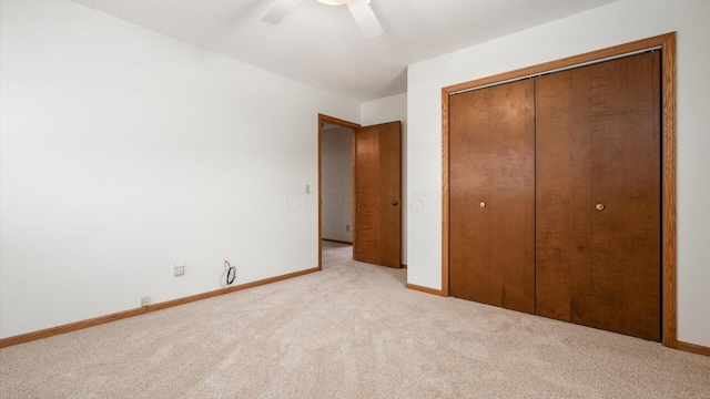 unfurnished bedroom featuring ceiling fan, light colored carpet, and a closet