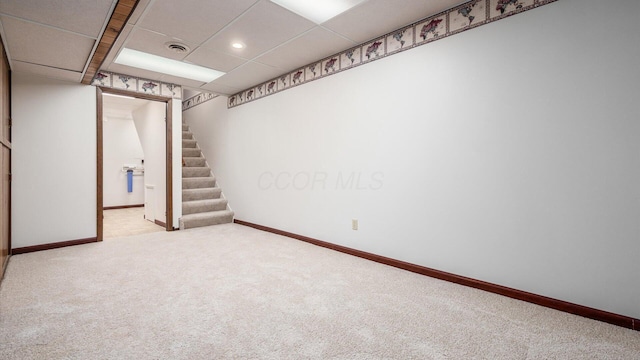 basement with light carpet and a drop ceiling