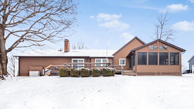 snow covered house featuring a wooden deck