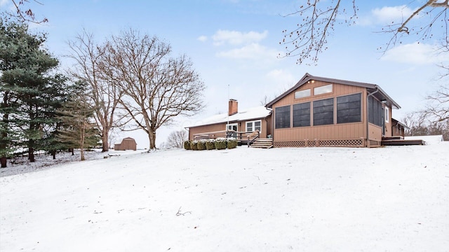 snow covered house with a sunroom