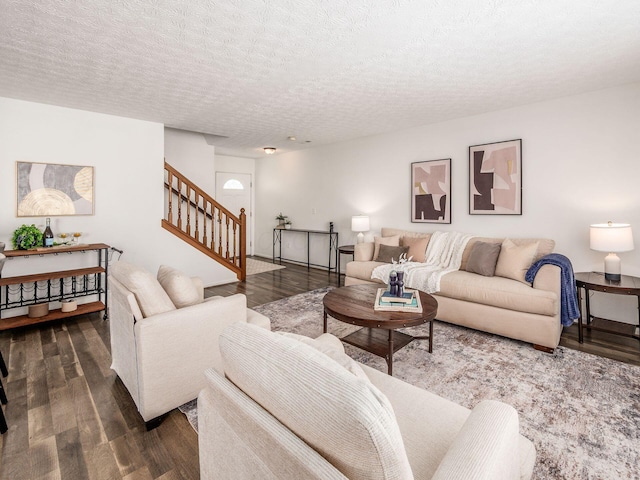 living room with a textured ceiling and dark hardwood / wood-style flooring