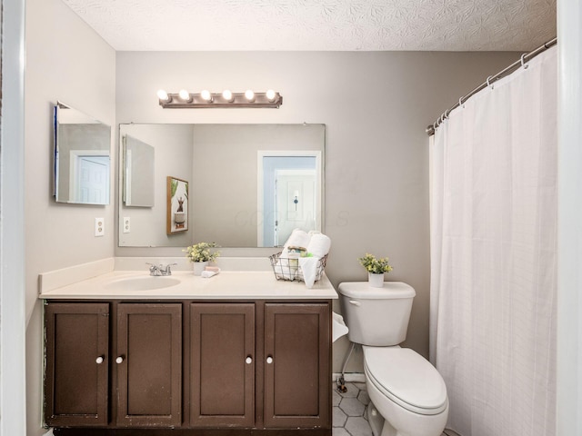 bathroom featuring toilet, tile patterned floors, vanity, and a textured ceiling