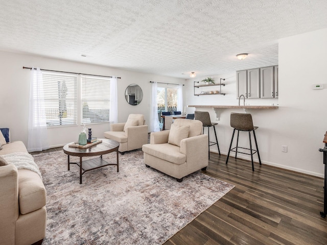 living room featuring a textured ceiling, dark hardwood / wood-style flooring, and plenty of natural light