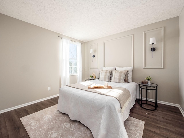 bedroom featuring a textured ceiling and dark hardwood / wood-style floors