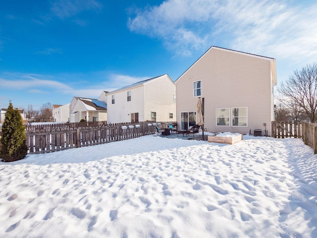 view of snow covered back of property