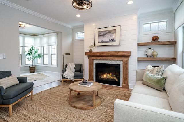 living room with plenty of natural light, ornamental molding, and a tile fireplace