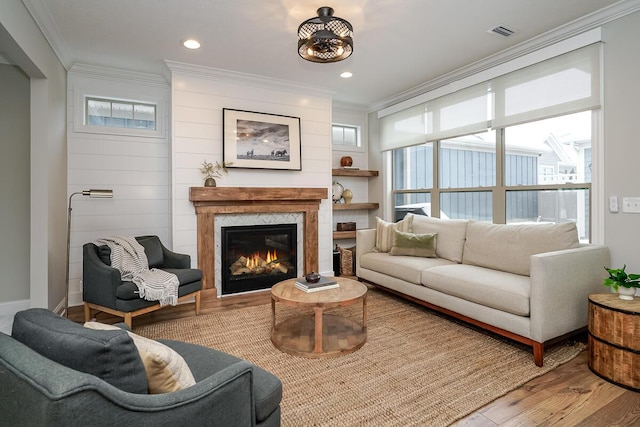 living room with light hardwood / wood-style floors, plenty of natural light, and ornamental molding