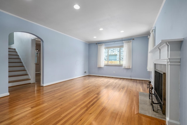 unfurnished living room with light hardwood / wood-style floors and crown molding