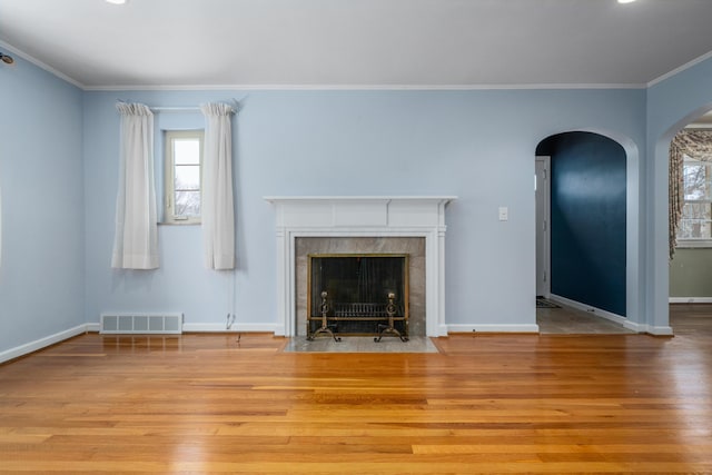 unfurnished living room featuring a fireplace, crown molding, and light hardwood / wood-style flooring