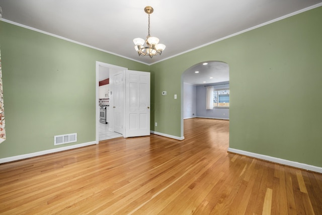 unfurnished room with a notable chandelier, light wood-type flooring, and crown molding